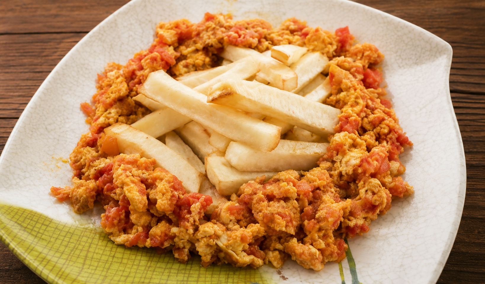 Fried yam sticks surrounded by a bright red tomato and egg sauce